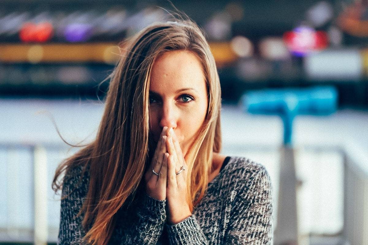 Woman with hands covering her mouth.