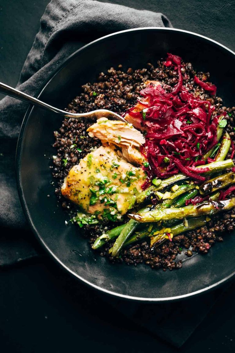 Salmon in a bowl with lentils, green beans, and sauerkraut.